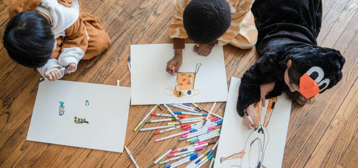 Mains d'enfant dessinant une carte du monde aux crayons de couleur, illustration du concours Barbara Petchenik