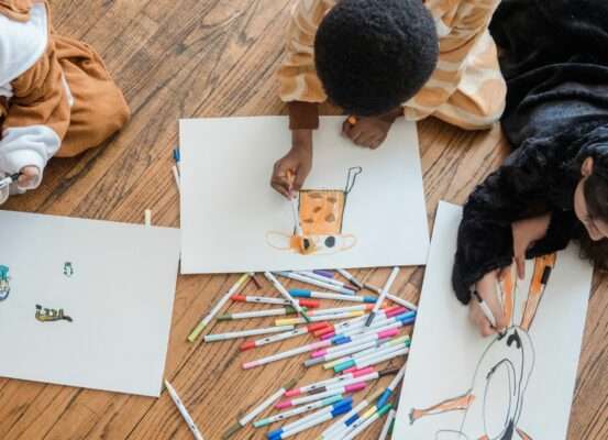 Les cartographies d'enfants du concours Barbara Petchenik : les gagnants de 2017 Mains d'enfant dessinant une carte du monde aux crayons de couleur, illustration du concours Barbara Petchenik